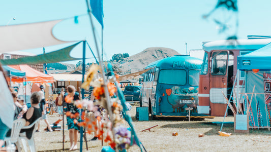 A market style fair is set up in a park on a sunny day