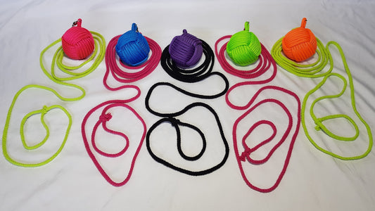 A row of five brightly coloured rope darts sit against a white backdrop