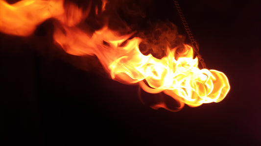 A fire rope dart burns brightly against a black background