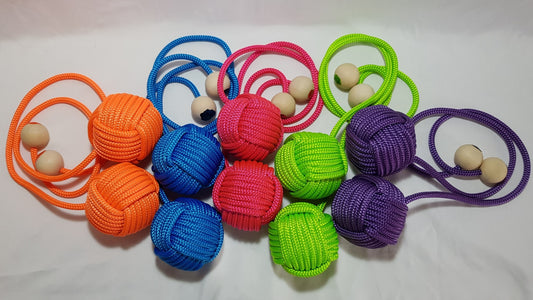 Five sets of brightly coloured poi sit against a white backdrop